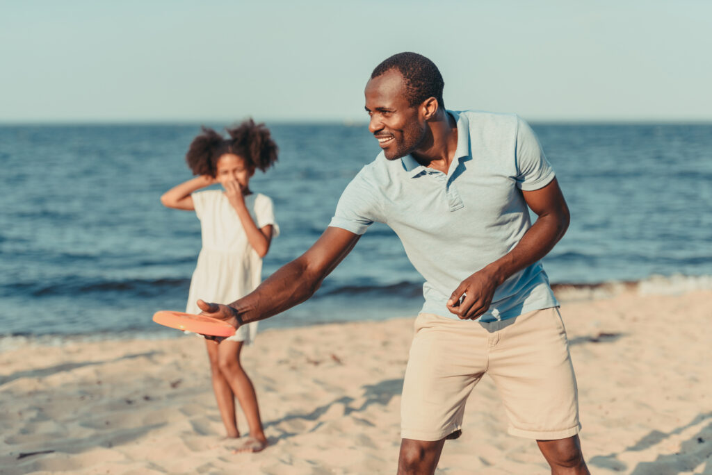 man throwing frisbee at the beach